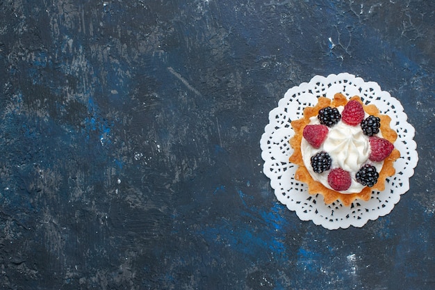 Vista dall'alto gustosissima torta dolce con diversi frutti di bosco e crema sulla scrivania grigio scuro frutta bacca color torta biscotto dolce