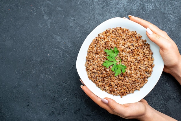 Vista dall'alto gustoso grano saraceno cotto all'interno del piatto su spazio grigio