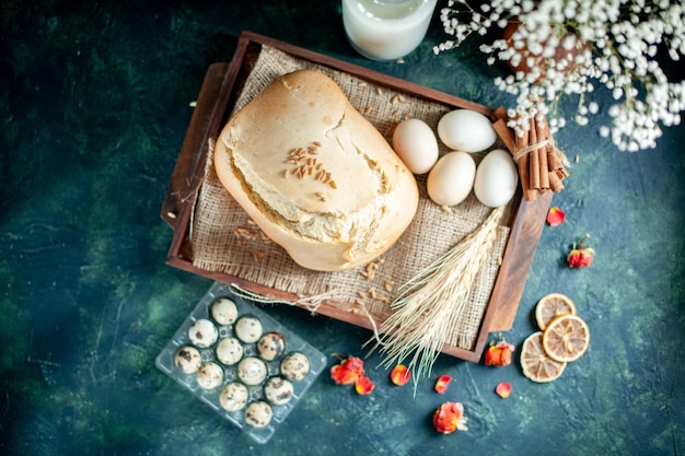 Vista dall'alto gustoso pane fresco con uova e latte su sfondo scuro torta torta tè zucchero panino biscotto colazione pasta cuocere