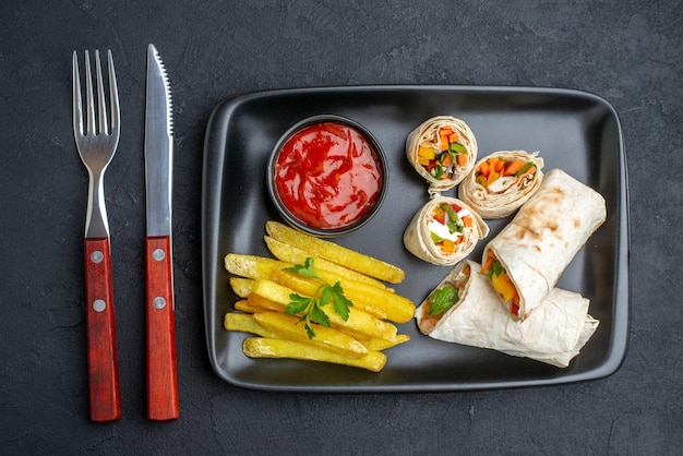 Vista dall'alto gustoso panino pita affettato shaurma con patatine fritte e ketchup su superficie scura hamburger cibo fast-food pasto griglia pane spuntino toast