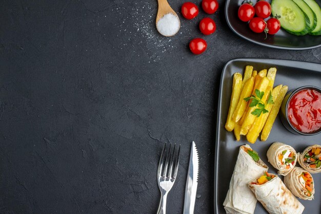 Vista dall'alto gustoso panino pita affettato shaurma con patatine fritte e ketchup su superficie scura