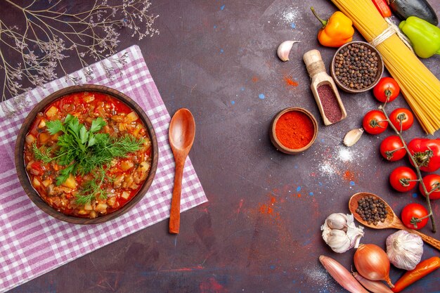 Vista dall'alto gustoso pasto di salsa di verdure cotte con condimenti diversi sullo sfondo scuro salsa pasto piatto di cibo