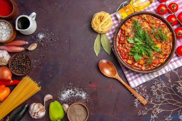 Vista dall'alto gustoso pasto di salsa di verdure cotte con pomodori e condimenti su sfondo scuro