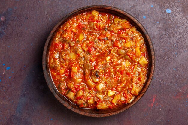 Vista dall'alto gustoso pasto di salsa di verdure cotte con verdure a fette sullo sfondo scuro pasto cena zuppa di salsa di cibo