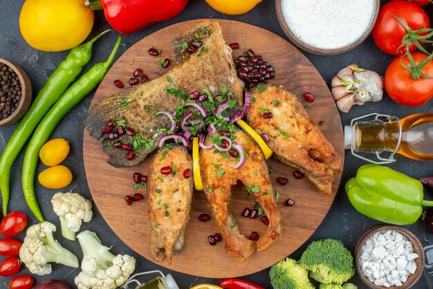 Vista dall'alto gustoso pesce fritto con verdure fresche e condimenti su sfondo grigio colore cibo insalata pasto salute frutti di mare carne oceano