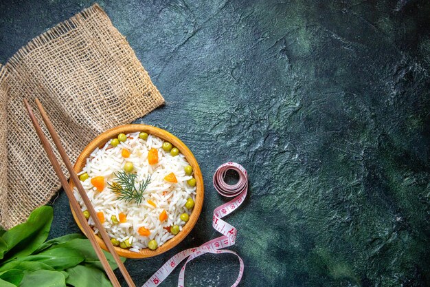 Vista dall'alto gustoso riso bollito con fagioli all'interno del piatto sulla scrivania scura