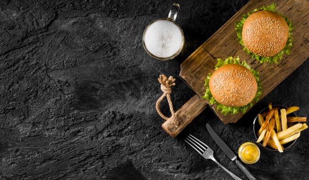 Vista dall'alto hamburger e patatine fritte con birra e copia-spazio