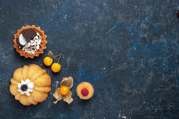 Vista dall'alto in lontananza della piccola torta deliziosa insieme al biscotto su torta di frutta dolce scura e biscotto