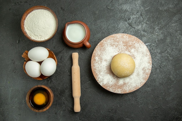 Vista dall'alto ingredienti per pasta uova latte farina sullo spazio grigio