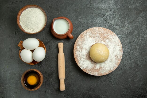 Vista dall'alto ingredienti per pasta uova latte farina sullo spazio grigio