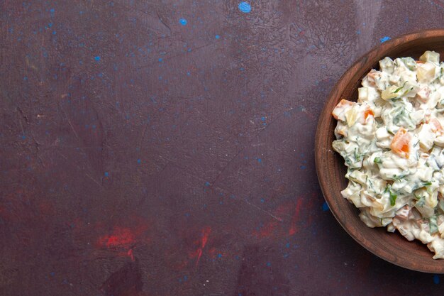 Vista dall'alto insalata di maionese con pollo all'interno della piastra su uno spazio buio