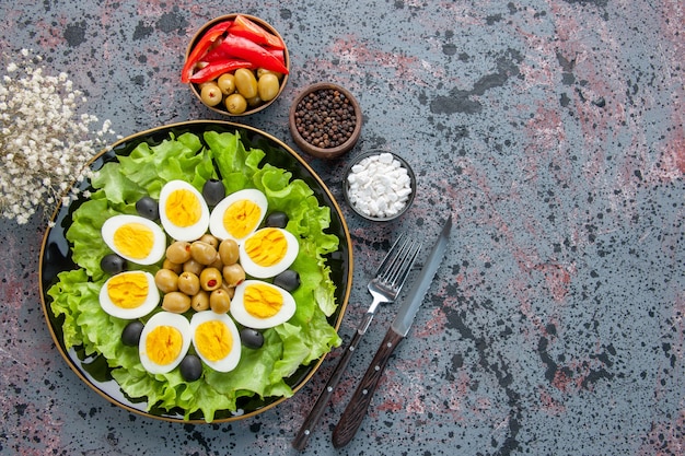 vista dall'alto insalata di uova è composta da insalata verde e olive su sfondo chiaro