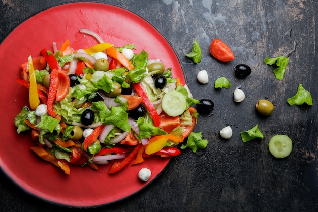 Vista dall'alto Insalata greca con pomodoro e olive e formaggio feta nel piatto rosso