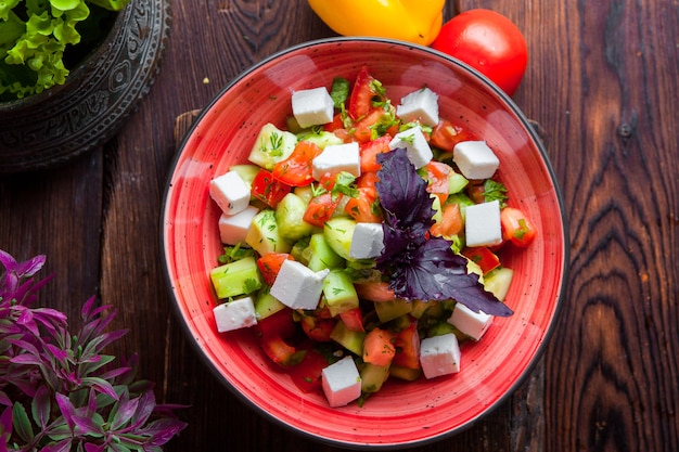 Vista dall'alto insalata greca lattuga, pomodori, formaggio feta, cetrioli, olive nere, cipolla viola