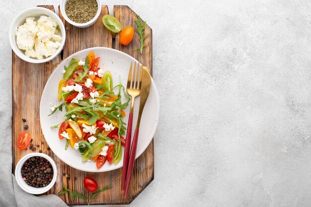 Vista dall'alto insalata mista di pomodoro con formaggio feta, rucola e copia-spazio