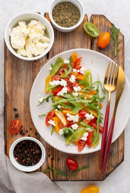 Vista dall'alto insalata mista di pomodoro con formaggio feta, rucola e pepe nero