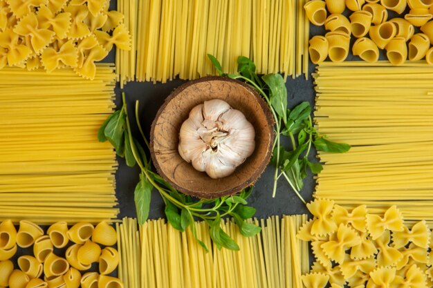 Vista dall'alto intera testa d'aglio e spaghetti crudi a forma di decorazione