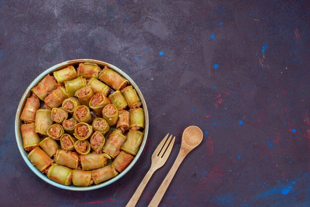 Vista dall'alto involtini di carne arrotolati con verdure all'interno della padella sullo sfondo scuro carne cena cibo pasto vegetale