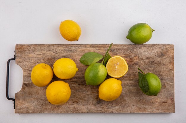 Vista dall'alto limette con limoni sulla lavagna su sfondo bianco