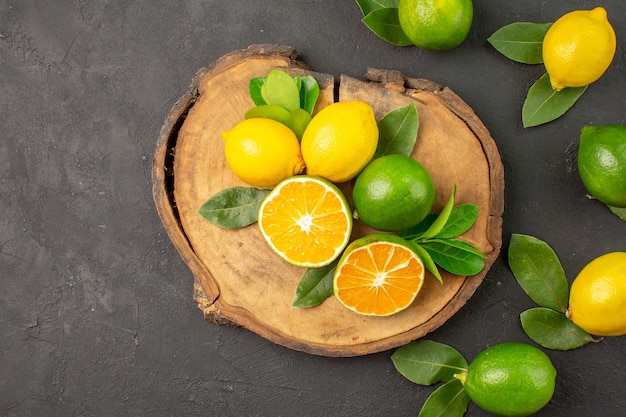 Vista dall'alto limoni freschi acida sulla calce di agrumi frutta tavolo scuro