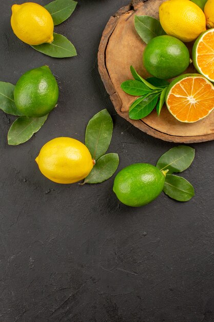 Vista dall'alto limoni freschi acida sulla calce di agrumi frutta tavolo scuro