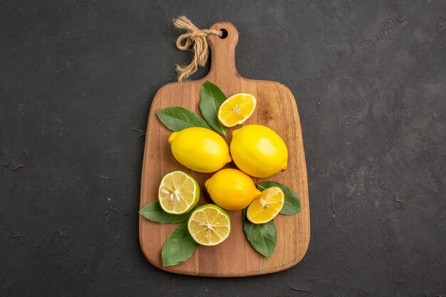 Vista dall'alto limoni freschi frutta acida sulla tavola scura agrumi calce