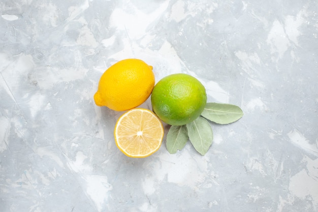 Vista dall'alto limoni freschi succosi e aspri sugli agrumi tropici della frutta esotica bianca della scrivania