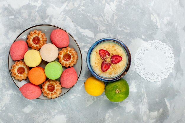 Vista dall'alto macarons francesi colorati deliziose torte con biscotti e dessert sulla scrivania bianca cuocere la torta dolce zucchero dessert biscotto