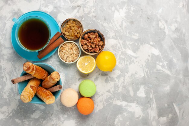 Vista dall'alto macarons francesi con una tazza di ciambelle di tè sulla superficie bianca