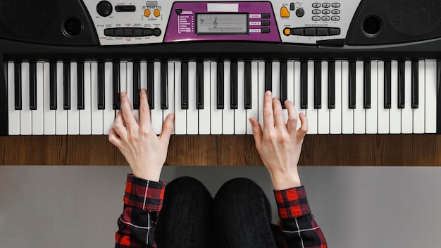 Vista dall'alto mani suonare il pianoforte digitale