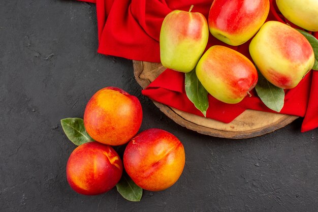 Vista dall'alto mele fresche con pesche sul tavolo grigio scuro colore di frutta fresca matura