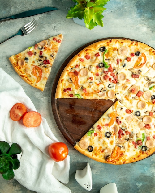 Vista dall'alto mescolare la pizza con salsicce di pollo funghi e olive sul tavolo