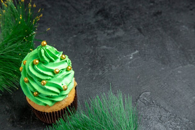 Vista dall'alto mini cupcake albero di natale e rami di albero di natale su superficie scura