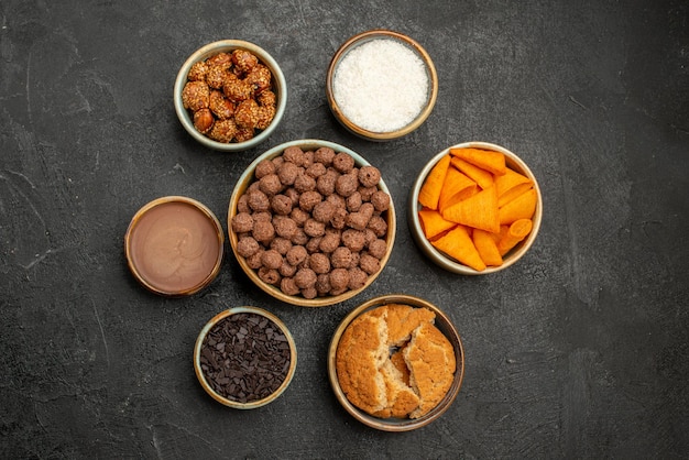 Vista dall'alto noci dolci con scaglie di cacao e cips su una superficie scura snack pasto latte colazione colore
