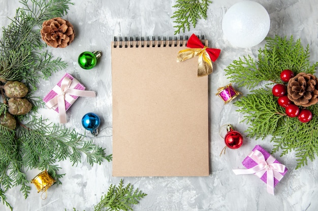 Vista dall'alto notebook albero di natale giocattoli rami di pino su sfondo grigio