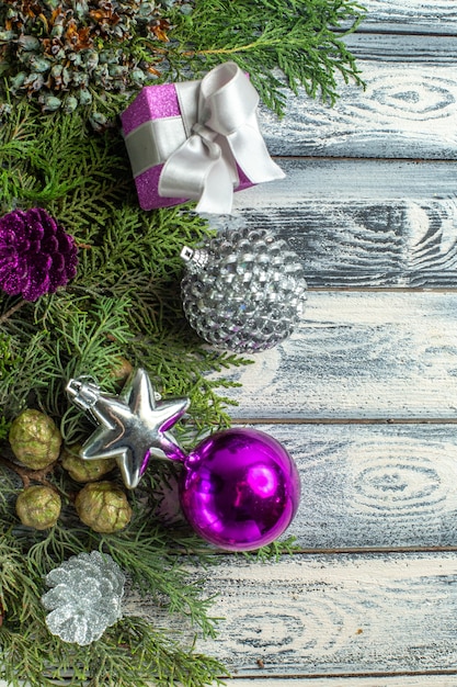 Vista dall'alto ornamenti di natale piccolo regalo rami di abete giocattoli di natale su superficie di legno