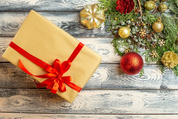 Foto gratuito vista dall'alto ornamenti di natale regalo di natale abete rami su sfondo di legno spazio libero