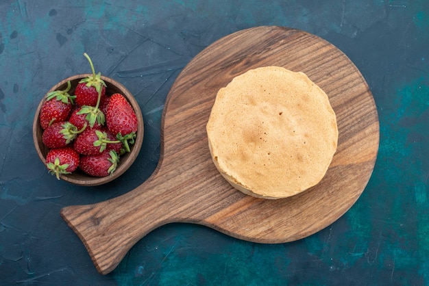 Vista dall'alto pasta al forno semplice al forno formata con fragole sulla scrivania blu scuro