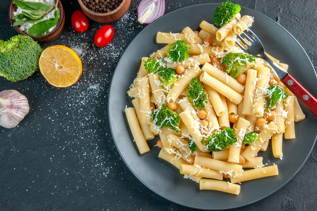 Vista dall'alto pasta cotta con broccoli e condimenti sfondo grigio scuro pepe colore pasta alimentare insalata foto femminile verde