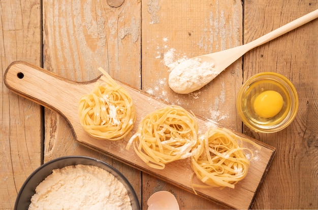 Vista dall'alto pasta cruda con uovo e farina