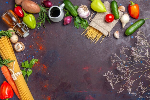 Vista dall'alto pasta cruda fresca con verdure su insalata di superficie scura pasto vegetale salutare vegetable
