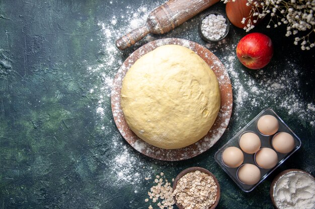 Vista dall'alto pasta fresca cruda con uova su sfondo scuro pasticceria cuocere torta pasta cruda torta forno fresco