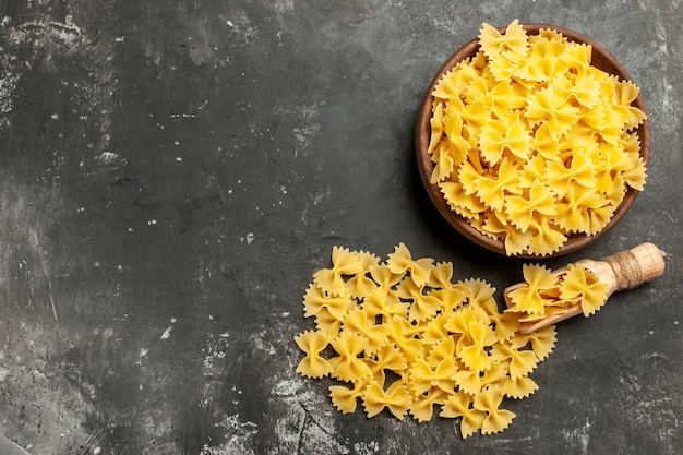 Vista dall'alto pasta italiana cruda all'interno del piatto su sfondo grigio scuro