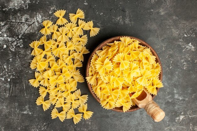 Vista dall'alto pasta italiana cruda all'interno del piatto su sfondo grigio scuro