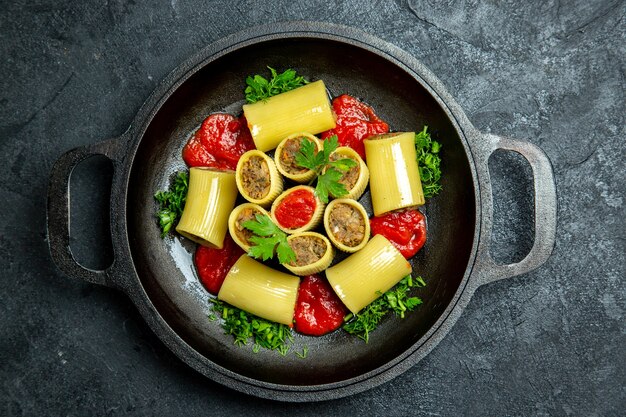 Vista dall'alto pasta italiana cruda con verdure di carne e salsa di pomodoro all'interno della padella sullo sfondo scuro pasta pasta pasto pasto