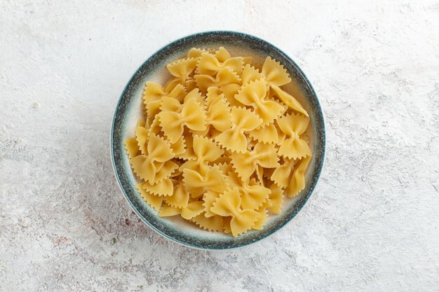 Vista dall'alto pasta italiana cruda poco formata sulla superficie bianca pasta italiana pasto pasta vegetale