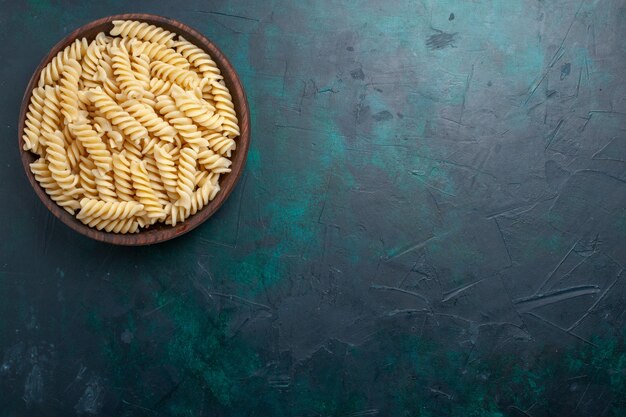 Vista dall'alto pasta italiana deliziosa guardando all'interno pentola marrone sulla scrivania blu scuro pasta italiana cibo pasto cena cucina pasta da cucina