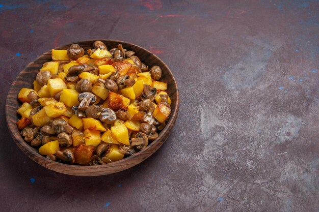 Vista dall'alto patate con funghi sulla superficie scura c'è una ciotola con patate e funghi