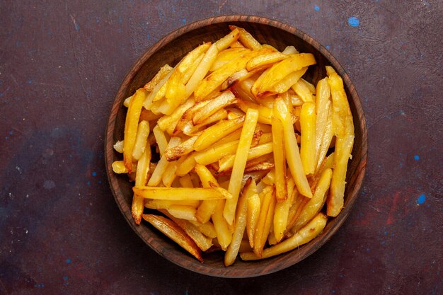 Vista dall'alto patate fritte gustose patatine fritte all'interno del piatto sulla superficie scura