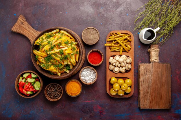 Vista dall'alto patate fritte gustose patatine fritte con verdure e condimenti diversi su superficie scura